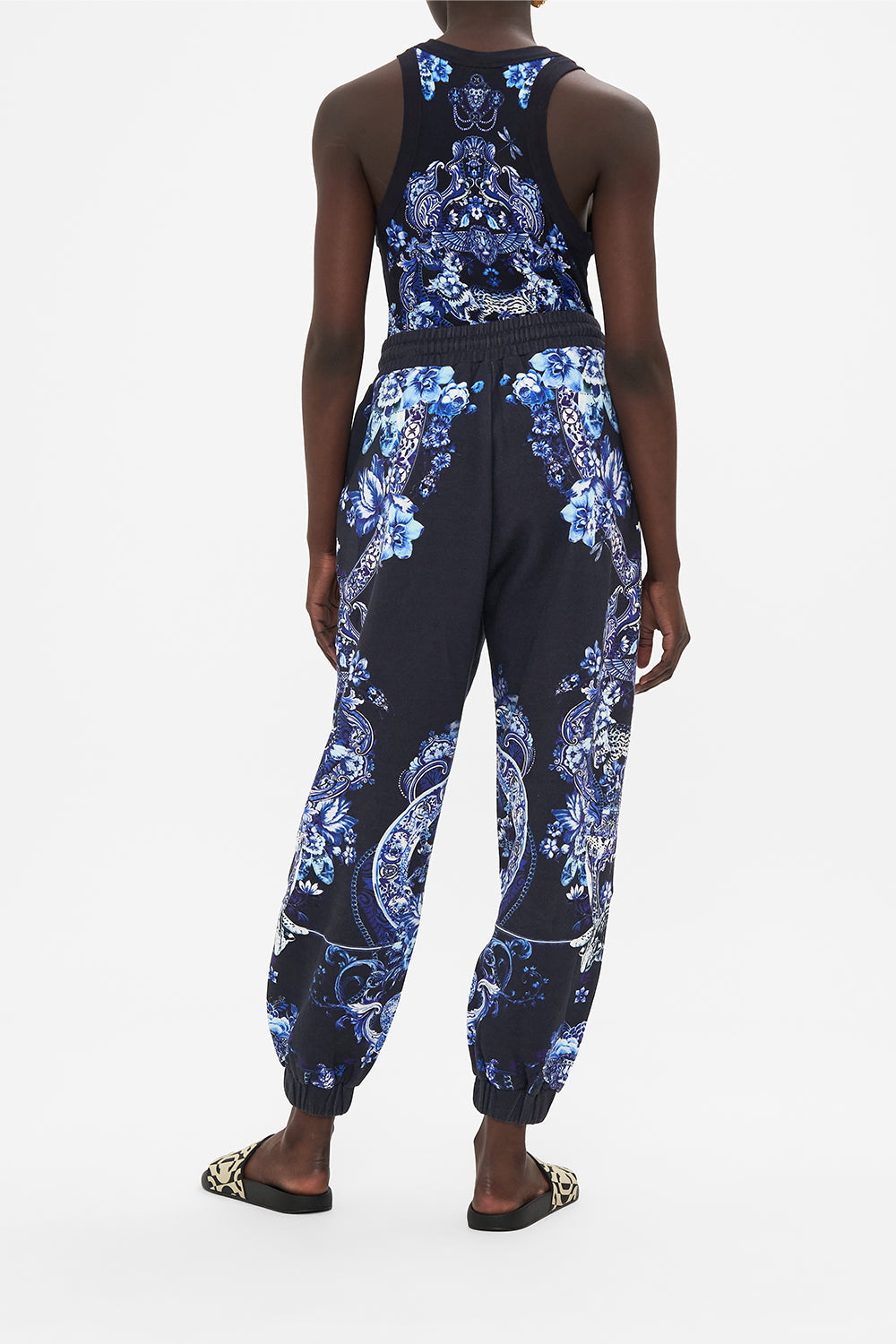 Back view of model wearing CAMILLA designer track pants in Delft Dynasty print