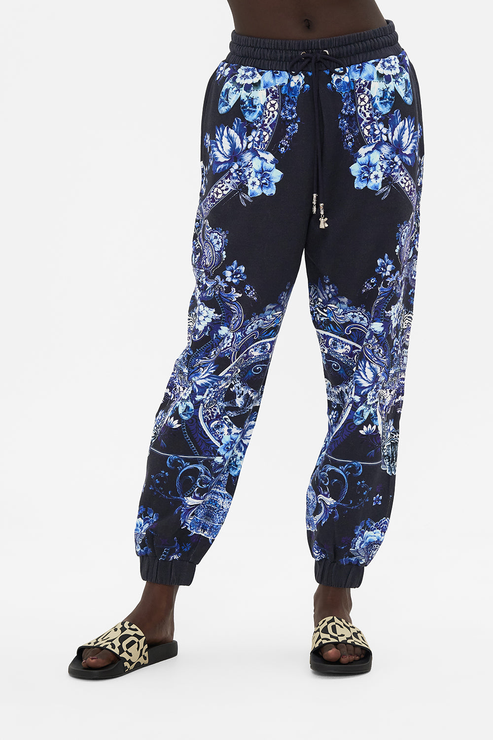 Crop view of model wearing CAMILLA designer track pants in Delft Dynasty print
