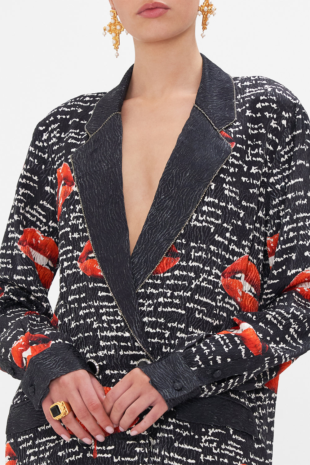 Detail view of model wearing CAMILLA black blazer in Chaos Magic print