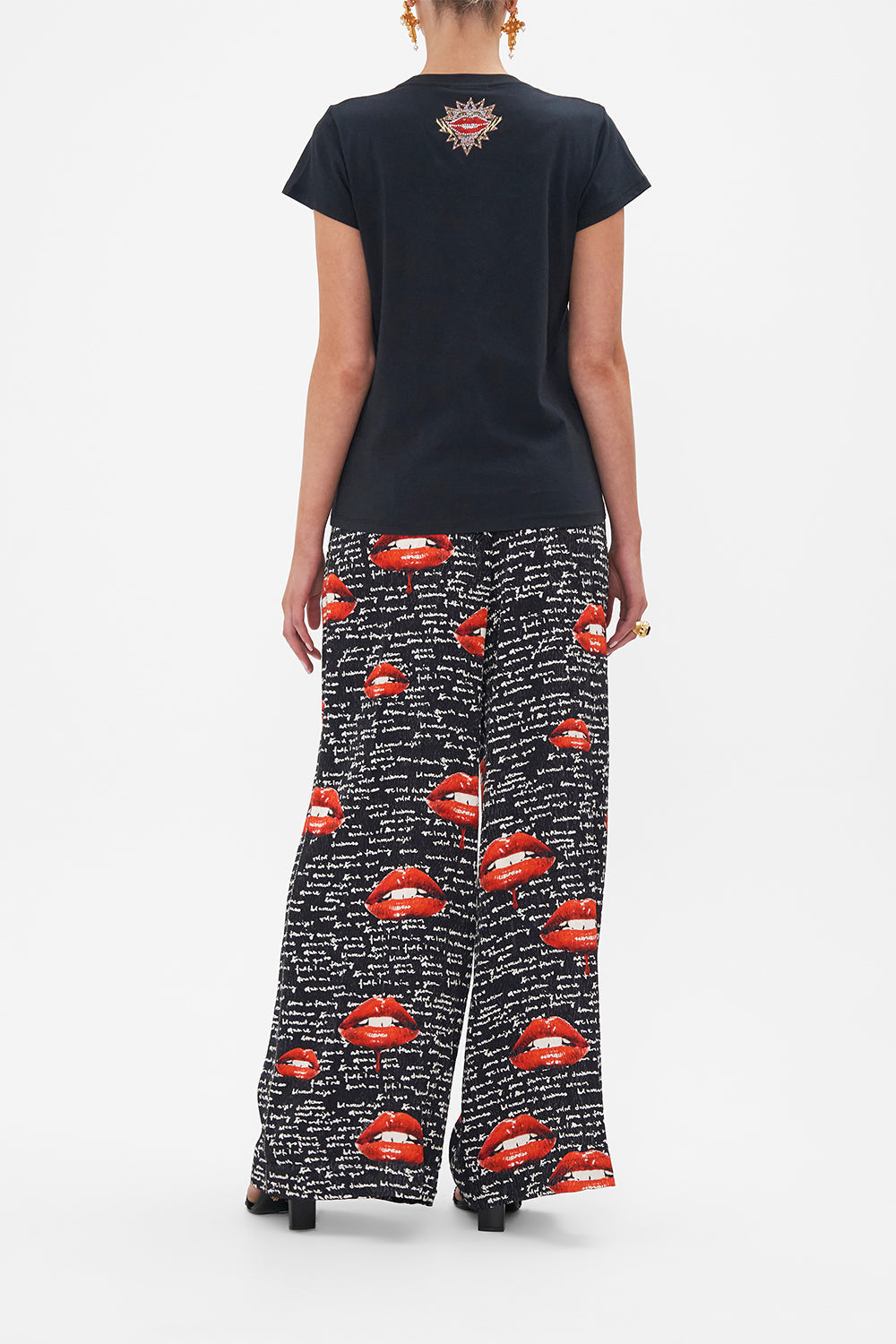 Back view of model wearing CAMILLA black graphic tee in Chaos Magic print