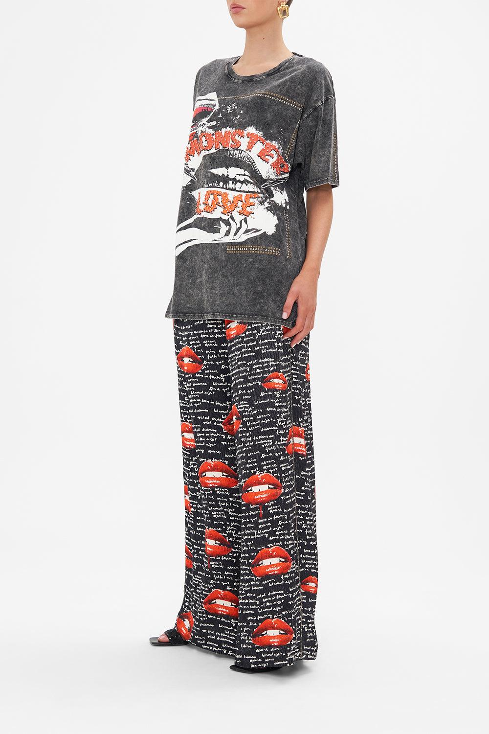 Side view of model wearing CAMILLA black acid wash graphic tee in Chaos Magic print