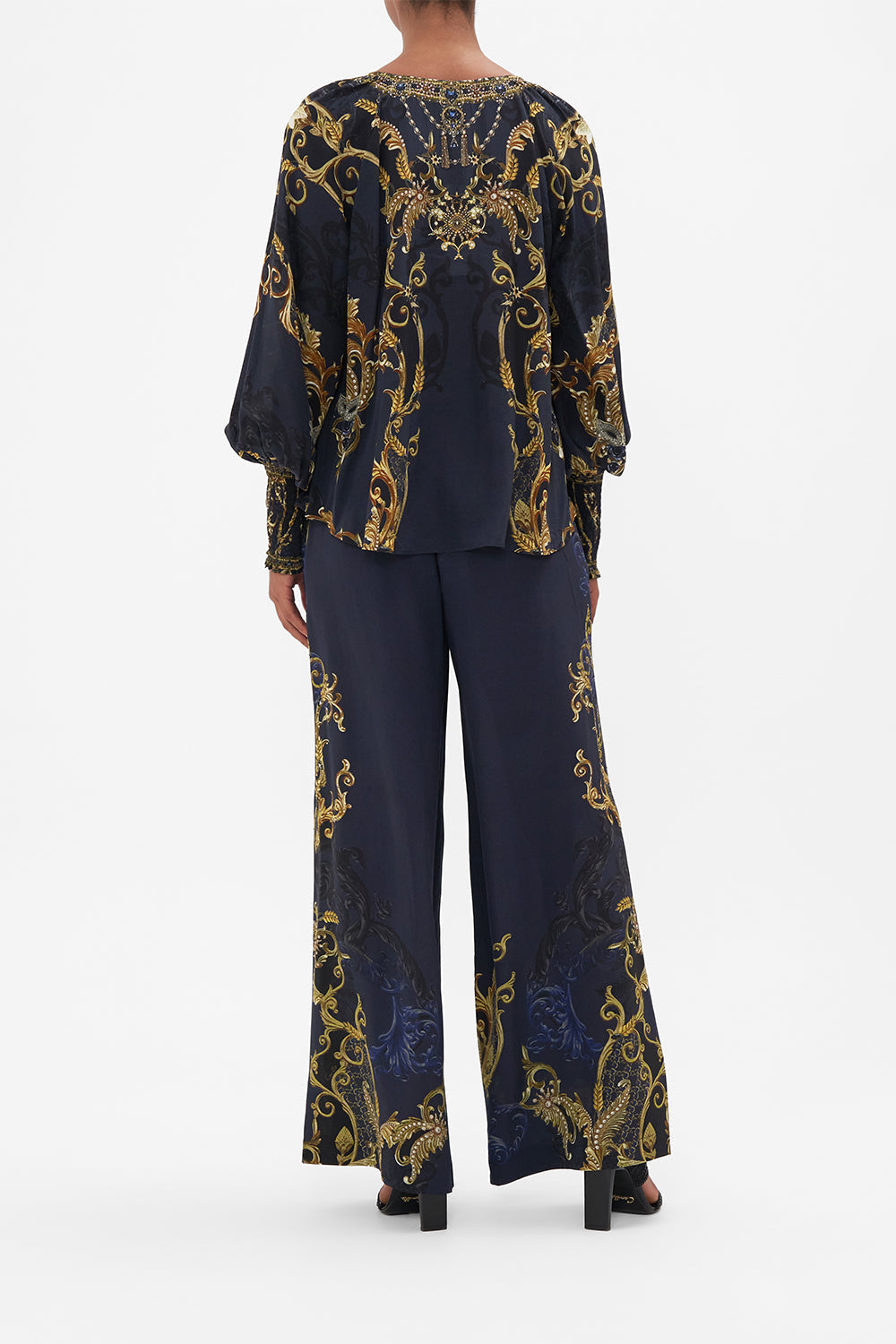 Back view of model wearing CAMILLA navy silk blouse in Moonlight Melodies print