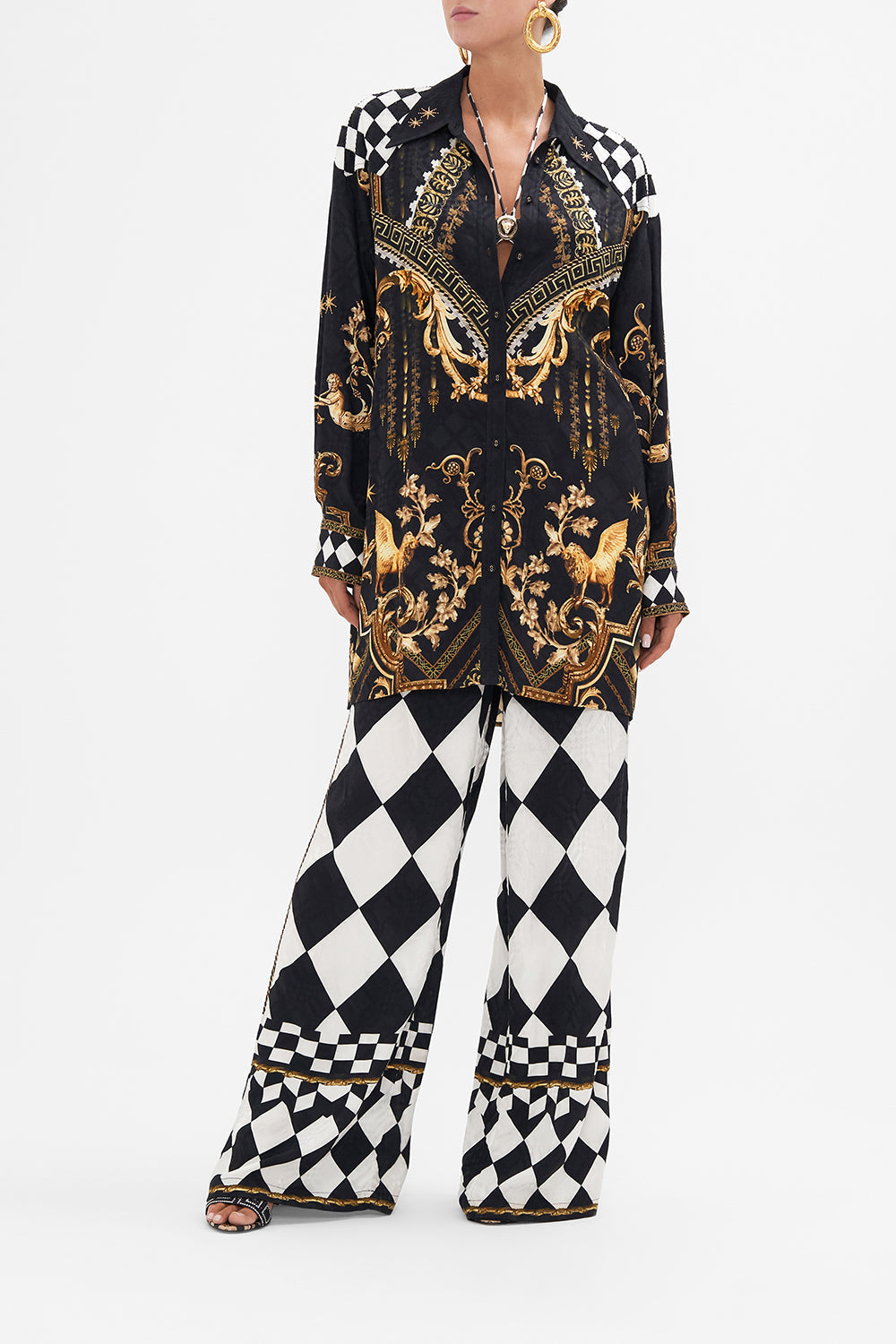 Front view of model wearing CAMILLA black and gold silk longline shirt in Duomo Dynasty print