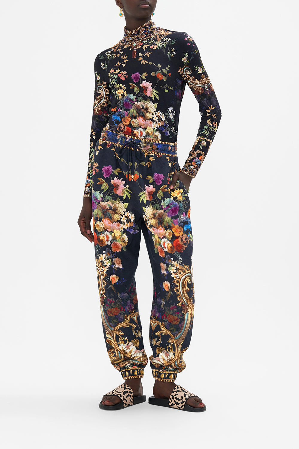 Front view of model wearing CAMILLA printed track pants in Play Your Cards Right print