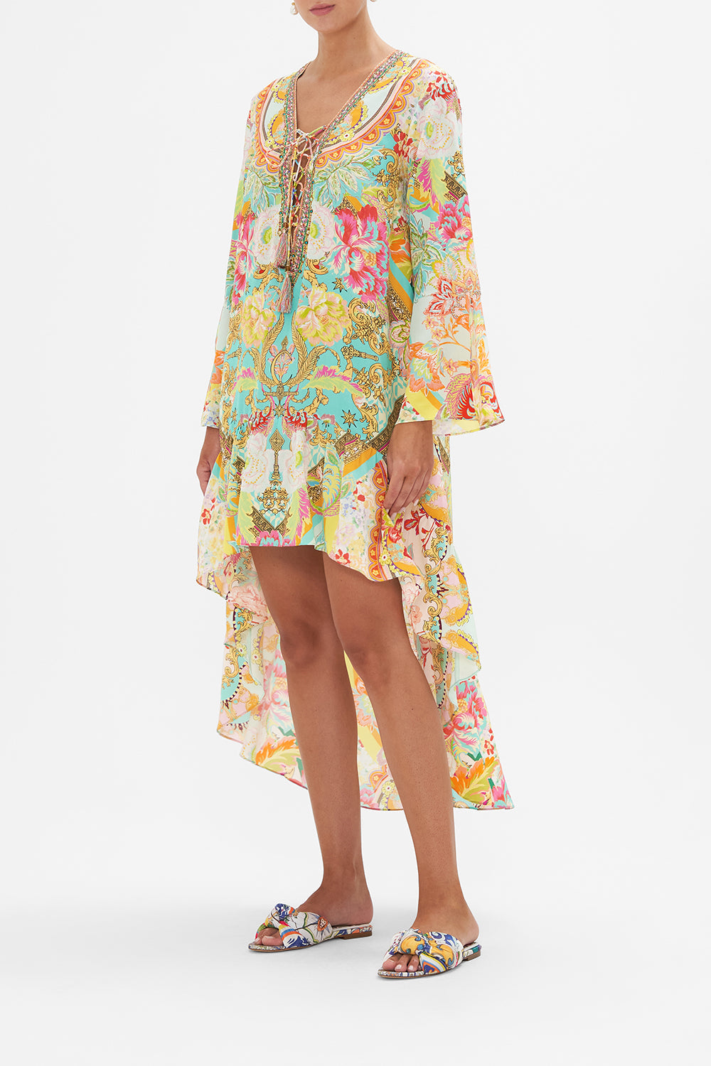 Side view of model wearing CAMILLA silk mini dress with high low hem in An Italian Welcome print