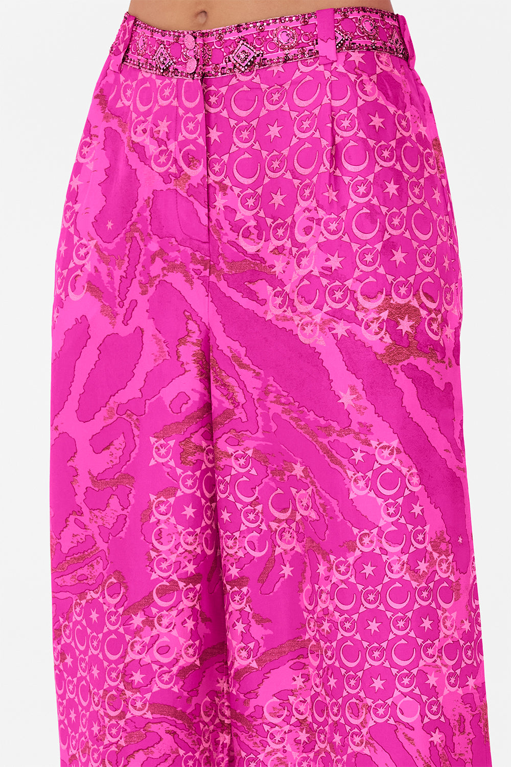 Detail view of model wearing CAMILLA silk pants in neon Song Of Sacrifice print