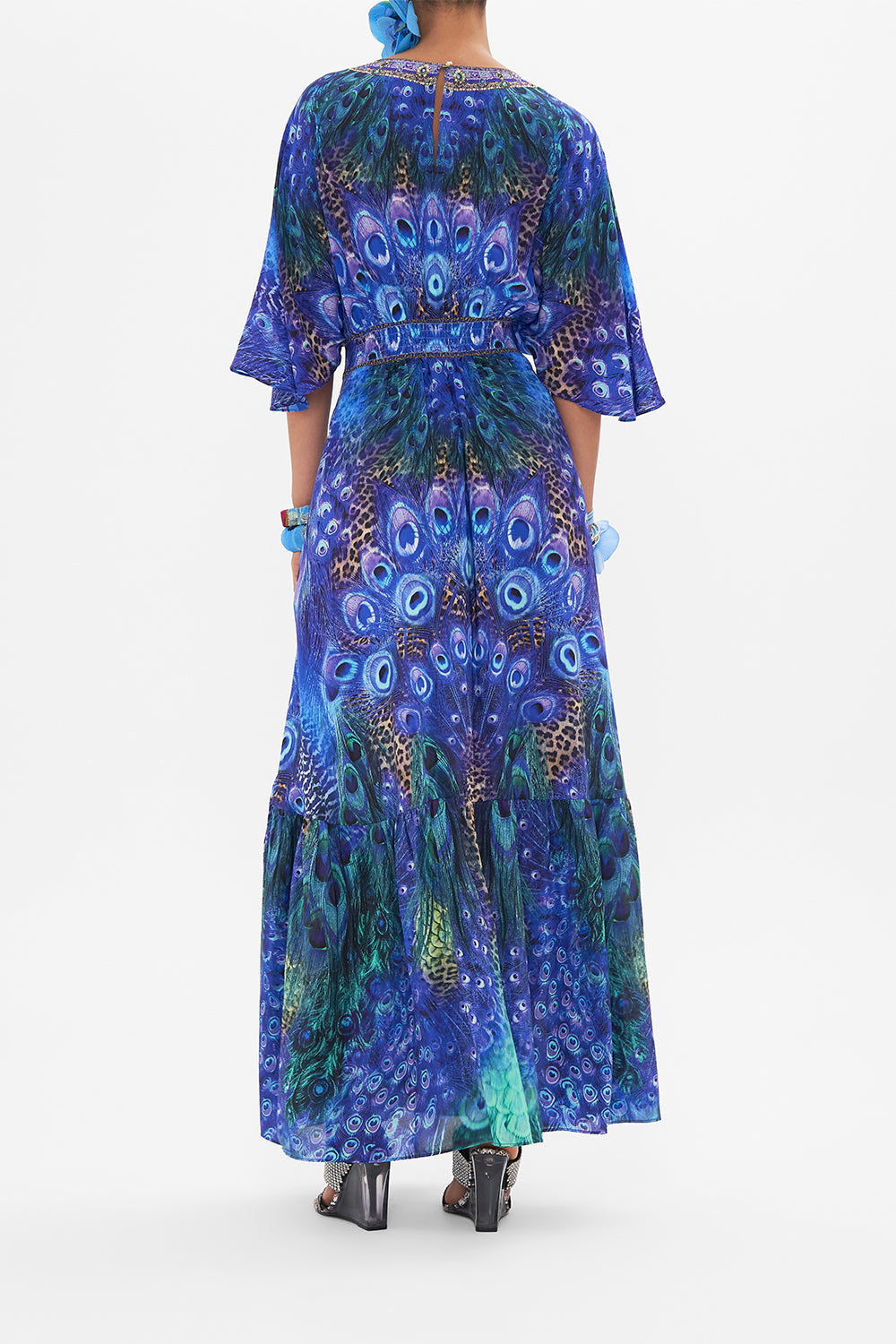 Back view of model wearing CAMILLA silk ruffle dress in Peacock Rock print