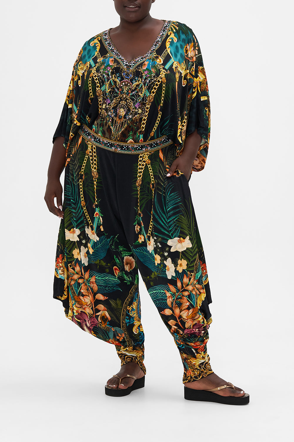 Front view of curvy model wearing CAMILLA plus size tropical print drape pants in Fearless Felis print