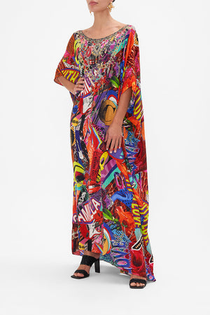 Side view of model wearing CAMILLA silk kaftan in multicoloured Radical Rebirth print