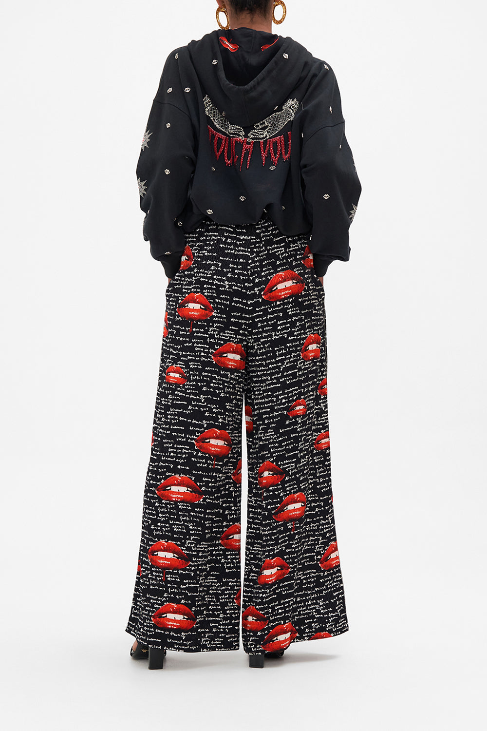 Back view of model wearing CAMILLA palazzo pants in black Chaos Magic  print