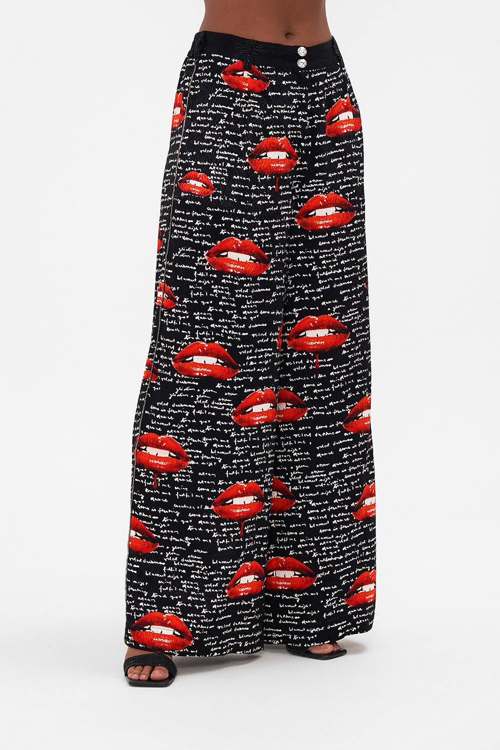 Crop view of model wearing CAMILLA palazzo pants in black Chaos Magic  print