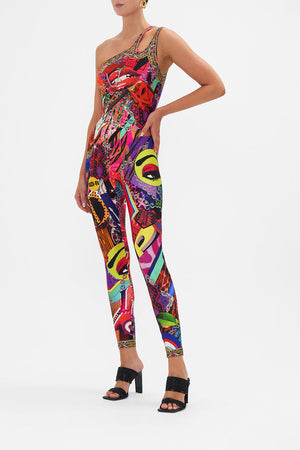 Side view of model wearing CAMILLA catsuit unitard in multicoloured Radical Rebirth print