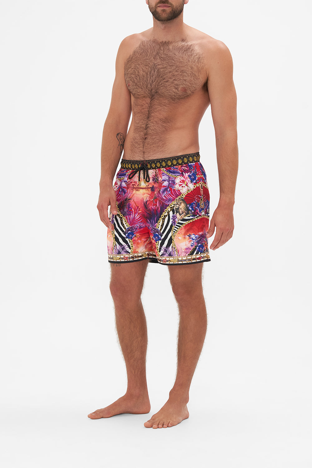 Side view of model wearing Hotel Franks by CAMILLA mens tropical print boardshorts in Wild Loving print