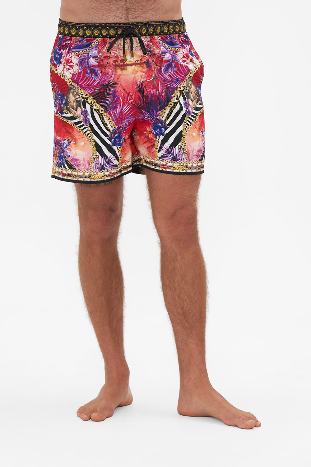 Crop view of model wearing Hotel Franks by CAMILLA mens tropical print boardshorts in Wild Loving print