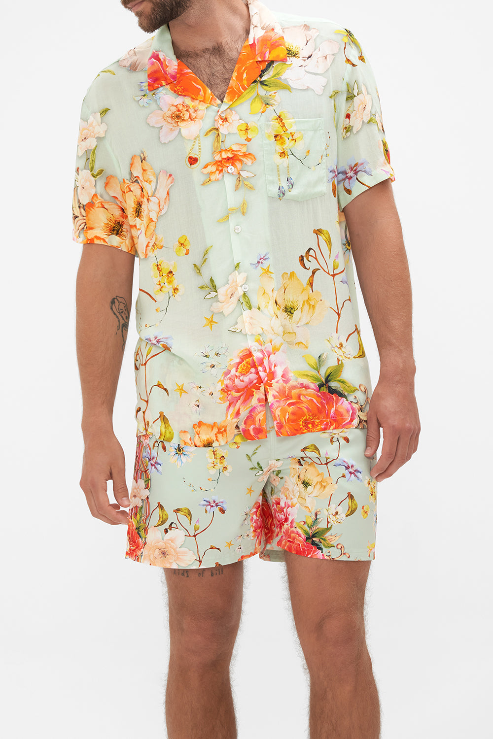 Crop view of model wearing Hotel Franks by CAMILLA mens floral short sleeved camp collared shirt in Talk The Walk print