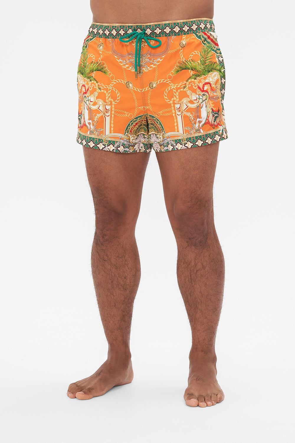 Crop view of model wearing Hotel Franks by CAMILLA silk mens short boardshorts in orange Dancing With The Bulls print