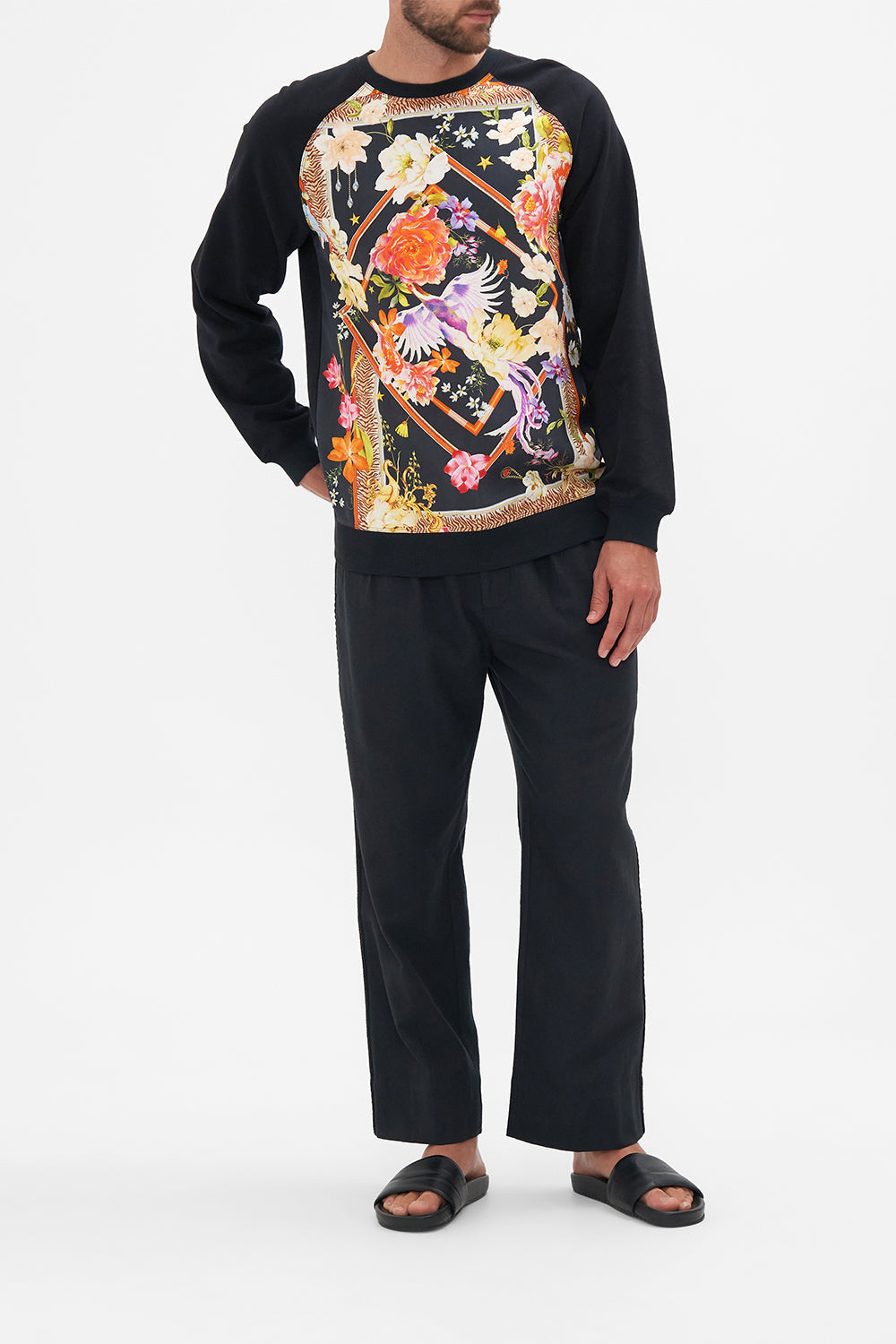 Front view of model wearing Hotel Franks by CAMILLA silk mens black knit jumper in Secret History floral print