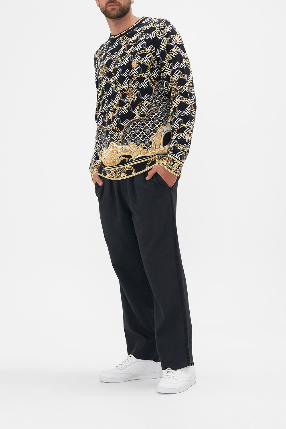 Side view of model wearing Hotel Franks by CAMILLA mens oversized knit sweater in black and gold Tether Me Not print