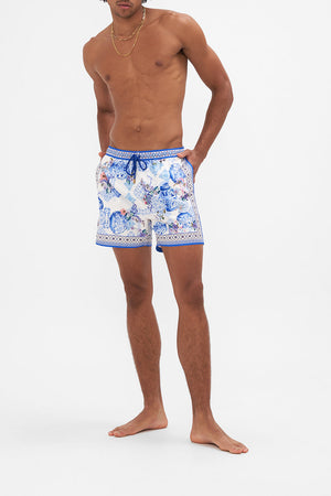 Front view of model wearing Hotel Franks by CAMILLA white and blue mid length mens short in Paint Me Positano print