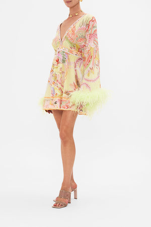 Side view of model wearing CAMILLA silk kimono mini dress with feathers in Cosmic Tuscan print