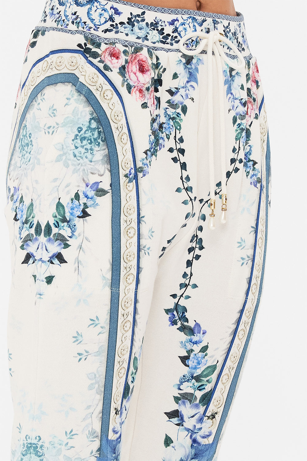 Detail view of model wearing CAMILLA designer pants in Season Of The Siren print 