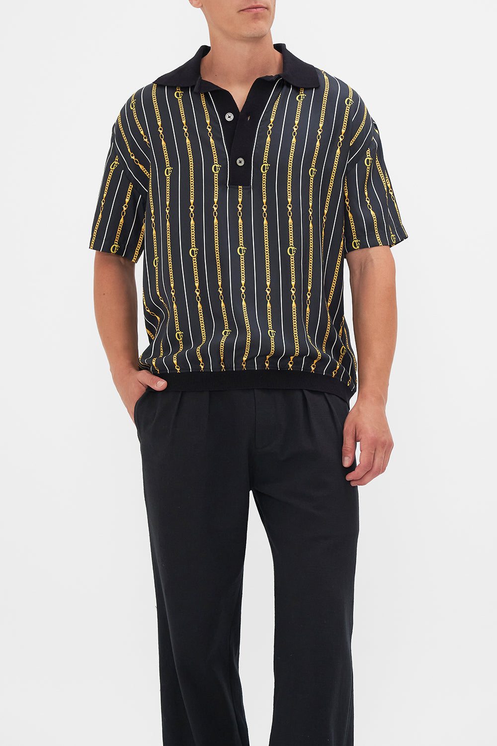 Crop view of model wearing Hotel Franks by CAMILLA mens shirt sleeve polo shirt in Coast to Coast print 