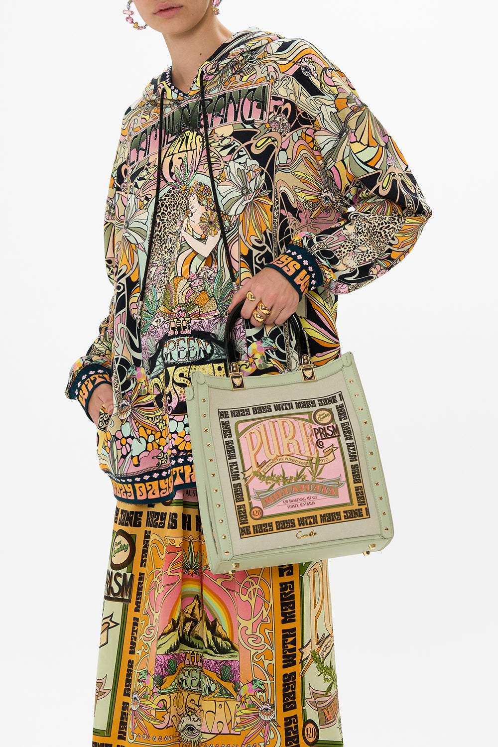 The CAMILLA NORTH SOUTH TOTE WITH SMOOTH HANDLE LETS CHASE RAINBOWS in our  print.