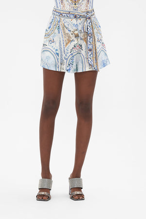 Crop view of model wearing CAMILLA designer silk shorts in Season Of The Siren print