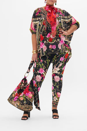 Front view of curvy model wearing CAMILLA plus size floral print leggings in Reservation For Love print