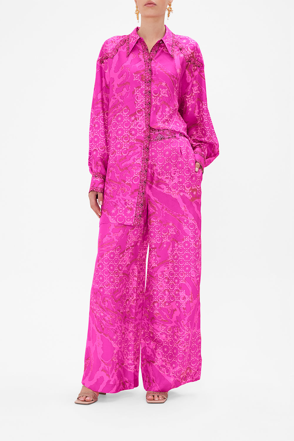 Crop view of model wearing CAMILLA silk shirt in neon Song Of Sacrifice print