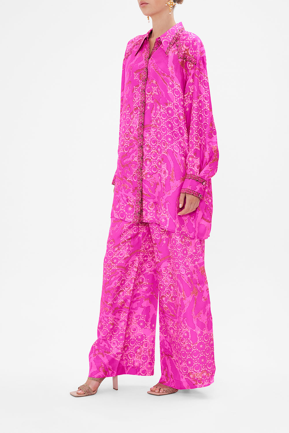 Side view of model wearing CAMILLA silk shirt in neon Song Of Sacrifice print