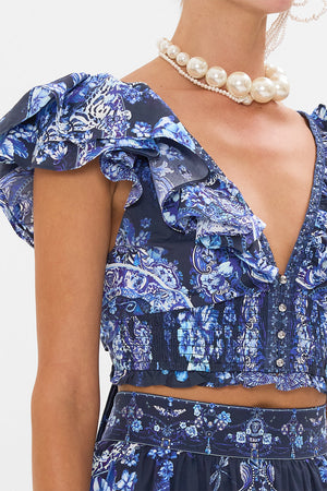 Detail view of model wearing CAMILLA ruffle top in Delft Dynasty print 
