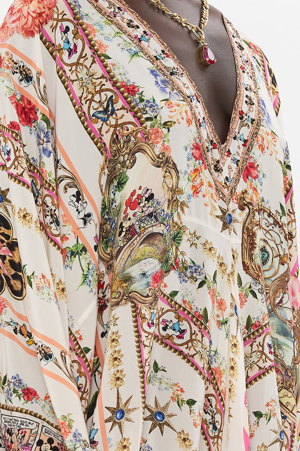 Detail view of model wearing Disney x CAMILLA silk kaftan in Minnie Magic Forever print 