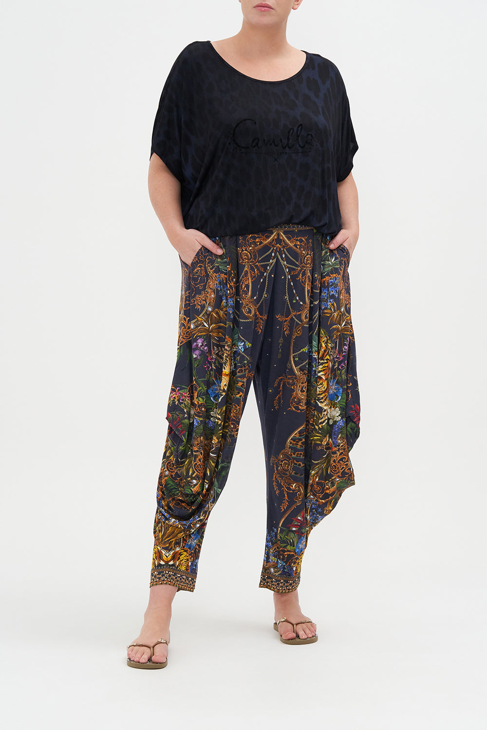Front view of curvy model wearing CAMILLA plus size jersey drape pant in Tiger Tales print
